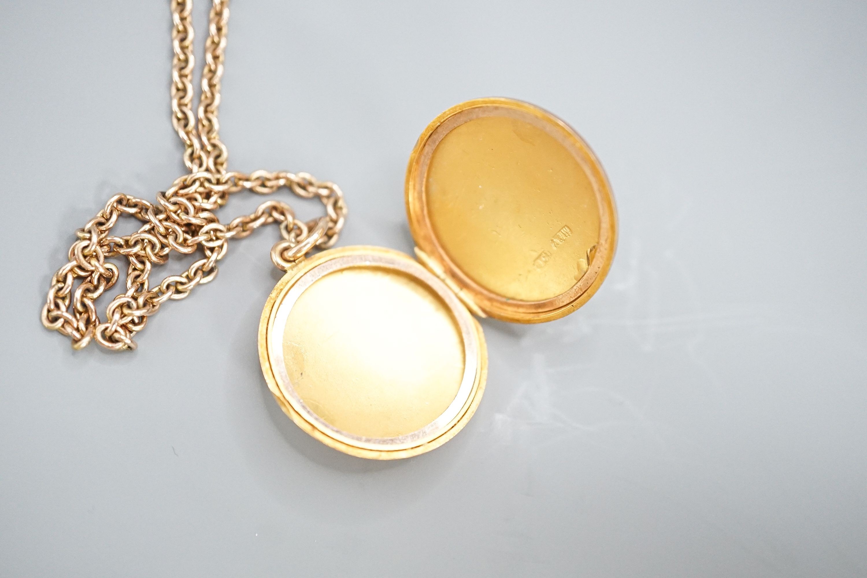 A 9ct circular locket, 26mm, on a 9k chain, 62cm, gross weight 21.2 grams.